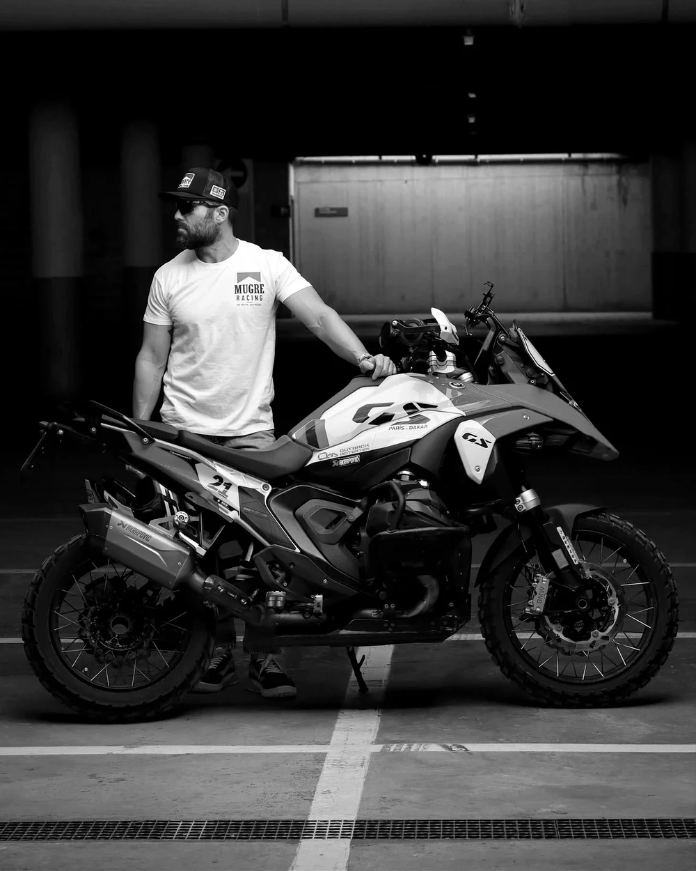 Rider con la camiseta RACING WHITE junto a su BMW GS